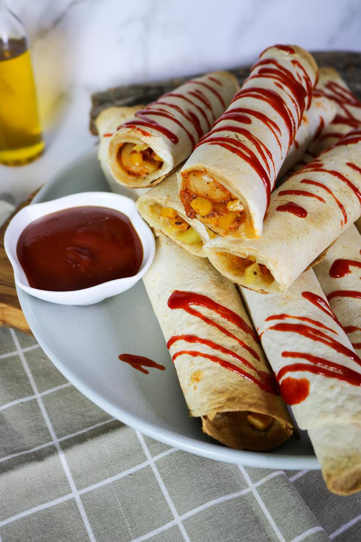 Vegan taquitos drizzled with sriracha sauce